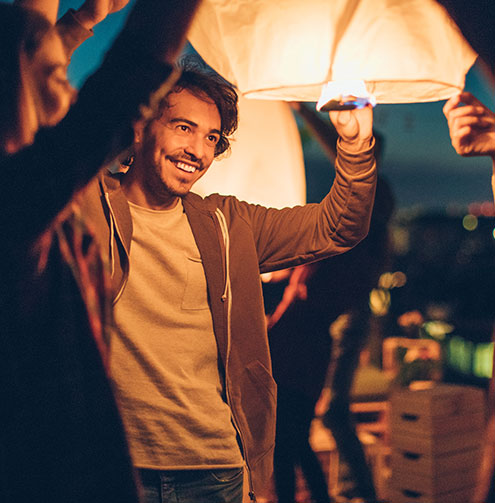 man smiling and releasing lantern